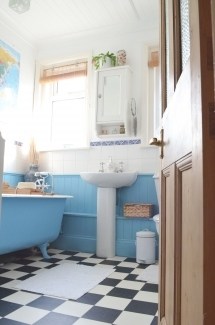 Coloured bathroom with patterned tiles flooring and blue freestanding bath by Anna, interior designer