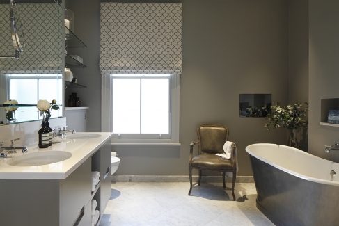 Grey bathroom with golden tones with freestanding bath by Laura, interior designer.